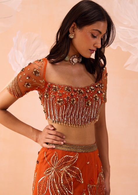 A blouse with intricate floral embroidered work and cutwork neckline paired with flora motifs sequin and zari work on skirt and dupatta. Burnt Orange Lehenga, Fashion Course, Outfit Poses, Sari Traditional, Orange Lehenga, Fashionable Saree, Pre Bridal, Blouses Designs, Fashion Garments