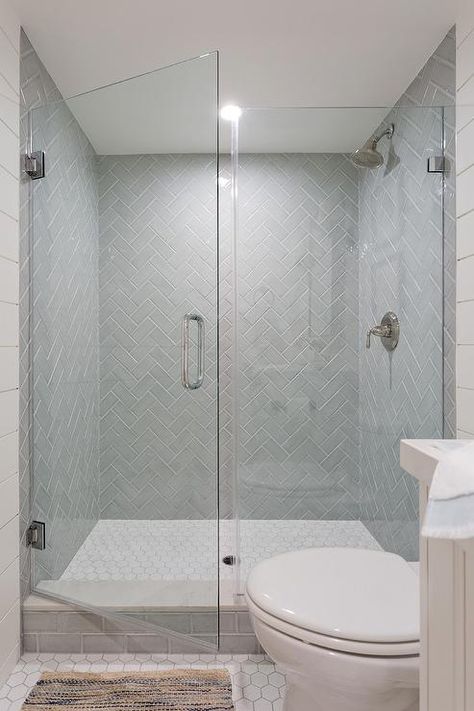 Gray herringbone pattern shower tiles in a walk-in shower enclosed with a seamless glass door. Tile Shower Glass Door Walk In, Tiled Shower Glass Door, Clear Shower Door Ideas, Stand Up Shower Glass Door Ideas, Frameless Shower Doors Master Bath, Glass Shower Door Height, Glass Door For Shower Walk In, Seamless Shower Door Walk In, Seamless Glass Shower Door