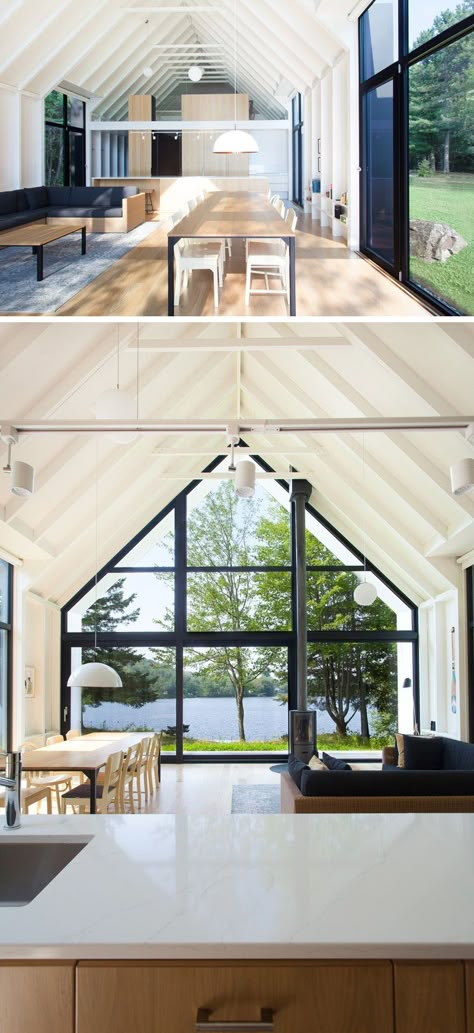 In the main living area of this modern vacation house, there's a kitchen, living area and dining area, that features a wall of glass that looks out to the lake and a large double-height gable extending outward to cover a small porch. #VacationHouse #Windows #InteriorDesign Small Porch, Double Height, Vacation House, Small Porches, Beach Cottage Style, Modern Windows, Modern Barn, Inside And Outside, Windows Exterior