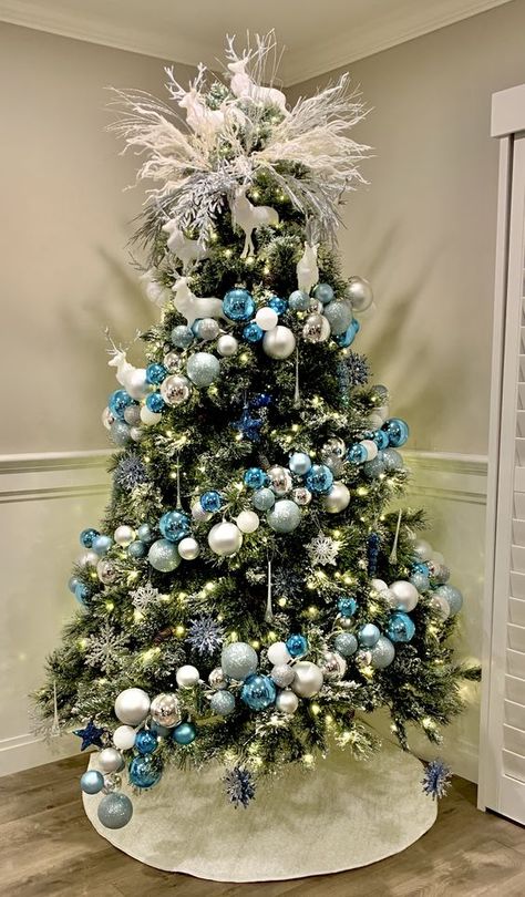 a chic Christmas tree with blue, silver and white ornaments, snowflakes, lights and white branches and deer on top One Color Christmas Tree Ideas, Blue And Silver Christmas Tree Ideas, Trendy Christmas Trees, Crismas Tree, Turquoise Christmas Tree, Blue Christmas Tree Decorations, Elegant Christmas Tree Decorations, Christmas Tree Inspo, Pretty Christmas Decorations