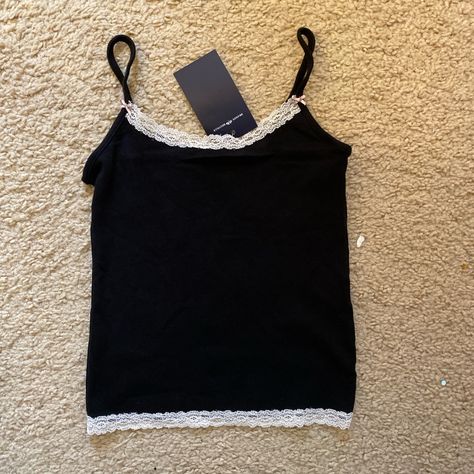 Soft, White Tank Top With A Scoop Neck, Bow And Lace Trim. Fabrics: 100% Cotton Measurement: 19" (49 Cm) Length, 13" (33 Cm) Bust Made In: China Cute Tank Tops Lace, Thrift Ideas, Lacy Tank Top, Tops Brandy Melville, Brandy Melville Tank Top, Thrift Inspo, Neck Bow, Cute Tank Tops, Hair Clothes