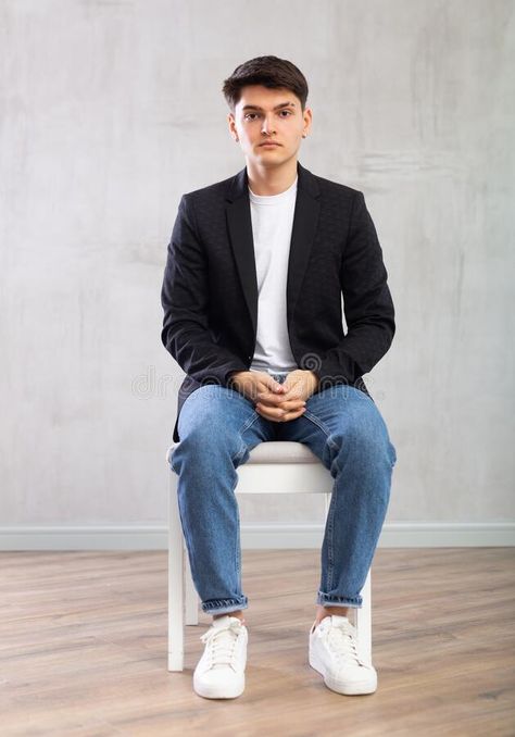 Charismatic young man sitting on chair in the middle of the room stock images Sitting Pose On Chair, Man Sitting In Chair Pose, Sitting On A Chair Pose, Person Sitting Reference Chair, Men Sitting Poses, Sitting Pose Reference Chair, Man Sitting Pose Reference, Man Sitting Pose, Sitting On Chair Poses