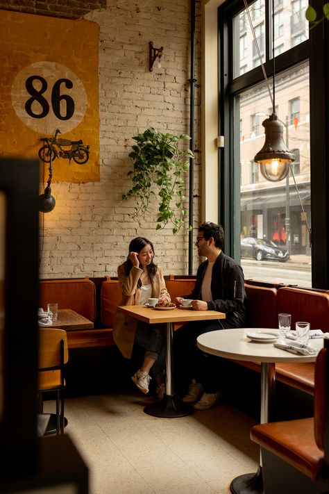 couple sitting in gastown coffee shop during engagement session Engagement Pictures Coffee Shop, Coffee Shop Prewedding, Coffeeshop Photoshoot Couple, Bakery Engagement Photos, Coffee Shop Engagement Shoot Photo Ideas, Coffee Shop Proposal, Cafe Photoshoot Ideas Couple, Cafe Couple Poses, Coffee House Engagement Photos