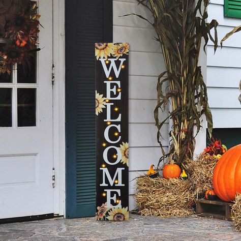 Features sentiment that reads Welcome, colorful finish and lovely sunflower motifs. Block combines a rustic backdrop with colorful embellishments and themed icons. Greet guests and passersby with a message of seasonal cheer with sunflower and WELCOME porch sign. The design can be enjoyed as is during the day, and then again at night when it's illuminated.1. 14 bulbs with warm white light2. 2 AA batteries are needed3. Decor makes a unique home decor item4. Porch sign will brighten any space in yo Harvest Porches, October Decor, Welcome Porch Sign, Themed Icons, Sunflower Home Decor, Porch Pumpkins, Rustic Backdrop, Wooden Porch, Wooden Welcome Signs