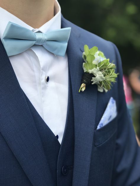 Navy blue suit and vest with light blue bow tie. Silver crested navy shirt studs and light blue white and navy blue patterned pocket square. Also a beautiful succulent boutonnière. Light Blue Tie Suit, Blue Suit Grey Waistcoat, Tuxes Wedding, Blue Tux Wedding, Navy Tuxedo Wedding, Blue Suit Bow Tie, Suit And Vest, Slate Blue Suit, Navy Blue Tux