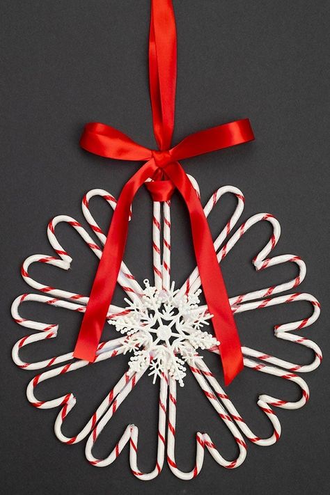 This candy cane wreath is SO CUTE and festive! It's so simple to make your own DIY Christmas wreath using candy canes from the dollar store. Both kids and adults will have fun making this easy Christmas craft that looks so pretty hanging on any door! Candy Cane Reef, Candycane Diy Decorations, Candy Christmas Wreaths Diy, Candy Cane Wreaths Diy How To Make, Plastic Candy Cane Crafts, Diy Candycane Wreaths, Candy Cane Garland Diy, Easy Holiday Wreaths Diy, Candy Cane Crafts Diy