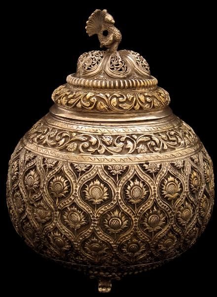 A Silver-Gilt Lidded Incense Burner North India, possibly Lucknow early 19th century height: 22cm This spherical incense burner stands on three cast feet and has an open-work lid surmounted by a solid-cast peacock. The body of the burner is chiselled and chased with Mughal-style flower heads within lattice borders. The lid, shoulder and base are  … Read more Silver Pooja Items, Wedding Gifts Packaging, Antique Jewelry Indian, Silver Decor, North India, Silver Ornaments, India Jewelry, Ancient Jewelry, Brass Decor