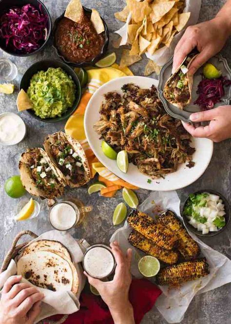 Overhead photo of Mexican Fiesta taco dinner party, with pork carnitas, tacos, grilled corn, guacamole, salsa, pickled red cabbage, tortilla chips and taco sides. Mexican Night Recipes, Cabbage Tortilla, Taco Sides, Taco Dinner Party, Mexican Dinner Party, Pickled Red Cabbage, Carnitas Tacos, Mexican Night, Guacamole Salsa