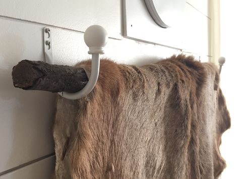 Inexpensive way to hang a deer hide! Get two curtain tie back hooks, and one tree branch. Screw them evenly on the wall. Place the branch across. Drape the hide over carefully and enjoy! Elk Hide Decor, Animal Hide Decor, Bear Skin Rug, Tie Back Hooks, Curtain Tie Back Hooks, Hunting Decor, Deer Hide, Skin Rugs, Welcome To My House