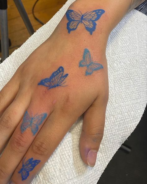 All Blue Tattoos For Women, Blue Butterfly Tattoo On Hand, Pretty Blue Tattoos, Blue Butterfly Hand Tattoo, Blue Tattoo Butterfly, Tattoo Blue Butterfly, Red Butterfly Hand Tattoo, Cute Simple Hand Tattoos, Blue Outline Tattoo