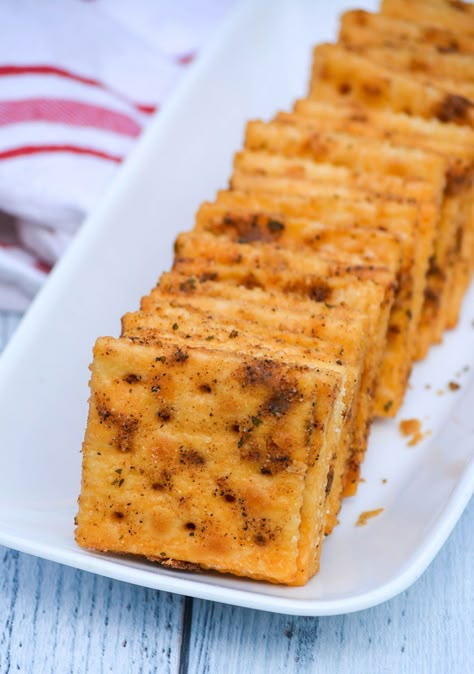 smoked saltine crackers arranged in a row on a small white platter Saltine Party Crackers, Smoked Saltine Crackers, Savory Party Cracker Seasoning Recipe, Spiced Saltine Crackers, Tennessee Hot Crackers, Mini Saltines Recipes, Fried Saltine Crackers, Dill Saltine Cracker Recipes, Seasoned Mini Saltine Crackers