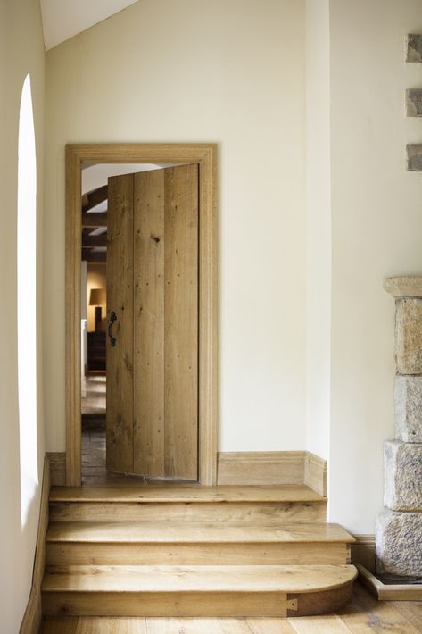 Oak steps leading to flagged hallway through rustic oak plank and batten door. Handmade by Jack Badger.  Photo Credit -Adrian Lambert Oak Cottage Doors Internal, Internal Stable Door, Internal Steps Ideas, Rustic Oak Doors, Farmhouse Internal Doors, Farmhouse Interior Doors Wood, Stone Corridor, Internal Steps, Cottage Doors Interior