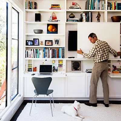 The new family room also functions as a home office, thanks to an ingenious floor-to-ceiling media center. A sliding door on the cabinets conceals the TV, and doors fold down into desks. File drawers and a printer station are concealed below—not a phone charger in sight. Printer Station, Hide Tv, Hidden Tv, Muebles Living, Wall Bookshelves, Living Room Shelves, Room Shelves, Beautiful Living Rooms, Living Room Diy