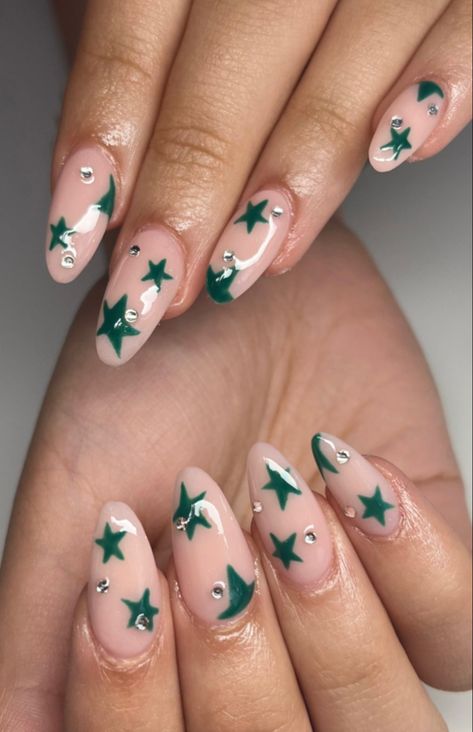 acrylic nails (pink/nude base) with green miss match stars and small dominates Green Almond Acrylic Nails Designs, Sage Green Nails With Stars, Green Star Nails Acrylic, Green And White Star Nails, Sage Green Star Nails, Dark Green Star Nails, Green Stars Nails, Star Christmas Nails, Green Nails With Stars