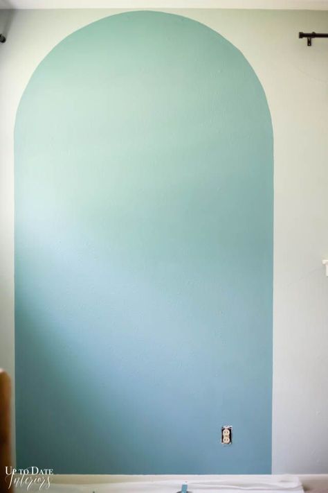 Change your room in an afternoon with a DIY painted arch accent wall and update a piece of furniture in the same color for a big impact! Head over to uptodateinteriors.com to see step by step instructions and video. #sponsored Paint Arches Bedroom, Arched Wall Painting, Arch Design On Wall, Painted Arch Feature Wall, Painted Arch Accent Wall Nursery, Diy Painted Arch On Wall, How To Paint Arch On Wall, Diy Geometric Wall Paint Patterns, Diy Painting Walls Ideas