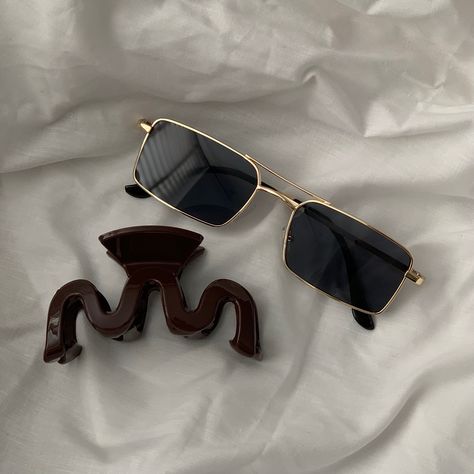 Gold vintage inspired sunglasses laying on white bedding with a chocolate brown hair claw Vintage Aesthetic Accessories, Aesthetic Sunglasses Vintage, Vintage Sunglasses Aesthetic, Hair Claw Aesthetic, Cool Sunglasses Aesthetic, Claw Aesthetic, Sunglass Aesthetic, Shades Aesthetic, Indie Sunglasses