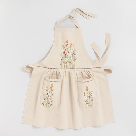 Dining & Kitchen -Practical meets chic in our natural cotton apron, featuring delicately embroidered florals and open-weave lace details at the waistband and on the two pockets. The stylish dress shape, with adjustable ties at the neck and waist, ensures one size fits most.   Also could be used for linens,kitchen linens,kitchen accessories,kitchen apron,kitchen smock,smock,coverall,kitchen coverup,clothes protection,clothes protector,pinafore,overall,bib apron. By Cost Plus World Market.5558 Fashion Apron, Floral Apron, Embroidered Apron, Retro Apron, White Apron, Cute Aprons, Sewing Aprons, Aprons Patterns, Cotton Apron