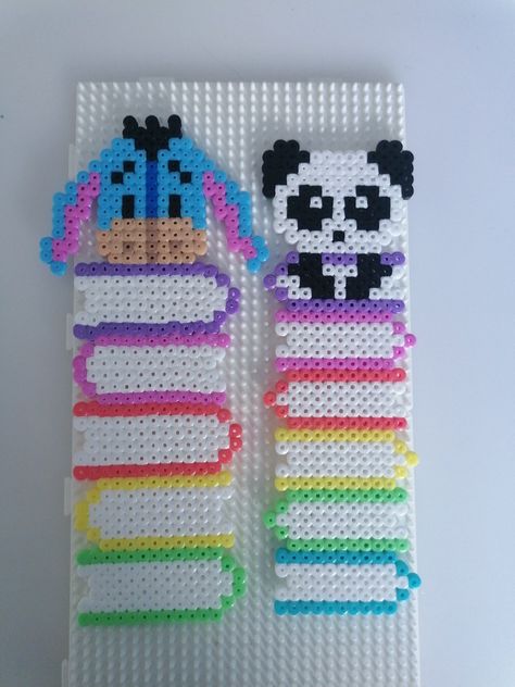 Handmade bookmarks from perler beads. Left one is a stack of books with eeyeore on top. Right one is a stack of books with a panda on top Pearler Beads Panda, Pyssla Ideas Bookmark, Hama Beads Bookmarks, Hama Beads Bookmark Ideas, Perler Art Ideas, Cute Perler Bead Bookmarks, Disney Perler Beads Ideas, Iron Beads Bookmark, Fuse Beads Bookmark