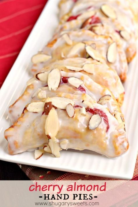 Easy, baked Cherry Almond Hand Pies! A flaky crust with a cherry almond pie filling, dipped in a sugary glaze and topped with sliced almonds. The perfect dessert! Cherry Almond Pie, Fruit Hand Pies, Almond Pie, Cherry Hand Pies, Hand Pie Recipes, Funnel Cakes, Shugary Sweets, Cake Mug, Cherry Desserts