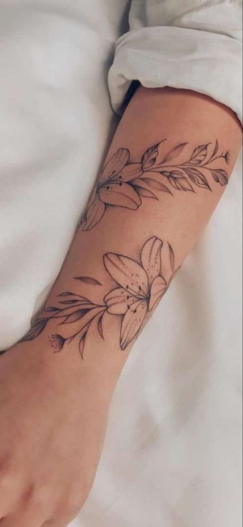 Simple Arm Wrap Tattoos For Women, Lily Tattoo With Vines, Flower Twist Arm Tattoo, Tiger Lily Tattoo Forearm, Lilly Wrist Tattoos For Women, Lily Flower Vine Tattoo, Lily Wrap Around Wrist Tattoo, Rose Arm Wrap Tattoo, Lilly Tattoo For Women Arm