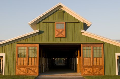 Large pea green barn with cream colored trim and lightly stained wood doors and shutters, green grass, light blue sky Agricultural Architecture, Exterior Barn Door Hardware, Custom Horse Stalls, Exterior Barn Doors, Green Barn, Fishing Cabin, Barn House Design, Barn Pictures, Riding Arenas