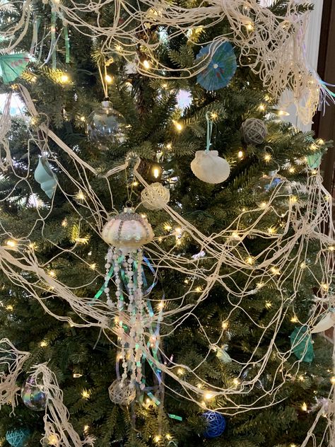 A blue and green color palette, white lights snd fisherman’s netting create this coastal Christmas in July tree Color Palette White, Fishing Christmas Tree, Coastal Christmas Tree, Green Color Palette, Fishing Christmas, Beach Christmas, Green Colour Palette, White Lights, Fishing Net