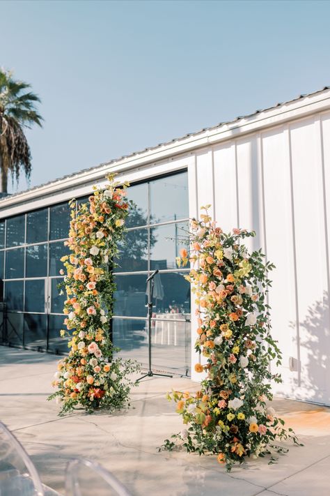 disconnected deconstructed wedding ceremony arch with lush orange yellow pink florals Pink Orange Wedding Flowers, Ceremony Arch Flowers, Wedding Floral Arch, Garden Whimsical, Orange And Pink Wedding, Fall Ceremony, Floral Arch Wedding, Orange Wedding Flowers, Citrus Wedding