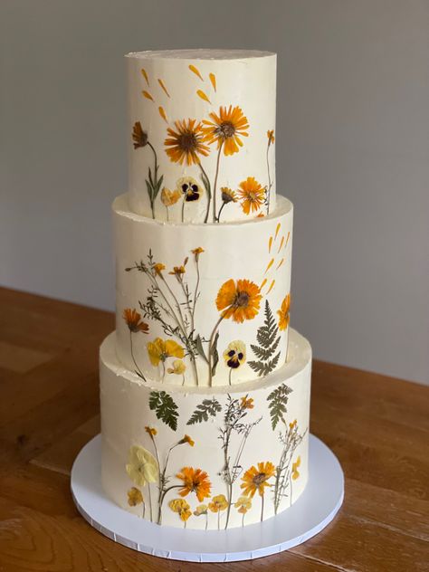 3 tiered buttercream wedding cake decorated with pressed flowers Yellow Flowers Wedding Cake, Pressed Flowers Wedding Cake, Wedding Cake With Pressed Flowers, Wedding Cake Wild Flowers, Wedding Cake Pressed Flowers, Pressed Flower Wedding Cake, Marigold Wedding Cake, Wild Flower Wedding Cake, Pressed Flower Cake