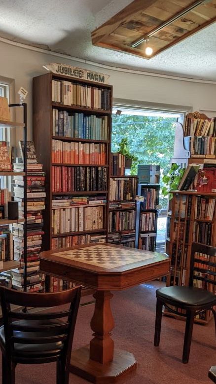 Book Shop Cafe Interior Design, Coffee Shop Reading Corner, Book Shop Cafe Aesthetic, Cozy Bookshop Cafe Aesthetic, Cafe With Books Coffee Shop, Small Bookshop Cafe, Book Store Cafe Aesthetic, Bookshop Cafe Design, Coffee Book Shop Design