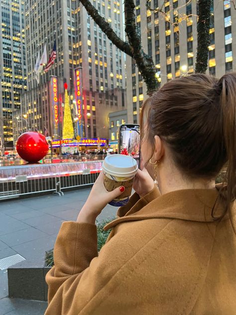 Young Woman in 20s/ Teen in college living in NYC New York during Christmas/ the holidays taking photos photography posing in Rockefeller Center drinking hot chocolate wearing a trench coat fashion stylish outfit with brunette hair hairstyles looking at a Christmas tree in the city with Christmas decorations and Christmas spirit in the winter Rockafella Center Christmas Aesthetic, New York Christmas Picture Ideas, Nyc Christmas Photoshoot, Nyc Christmas Bucket List, Nyc Christmas Aesthetic, Nyc Nye, New York Instagram Pictures, Nyc Romantic, New York Outfits Winter