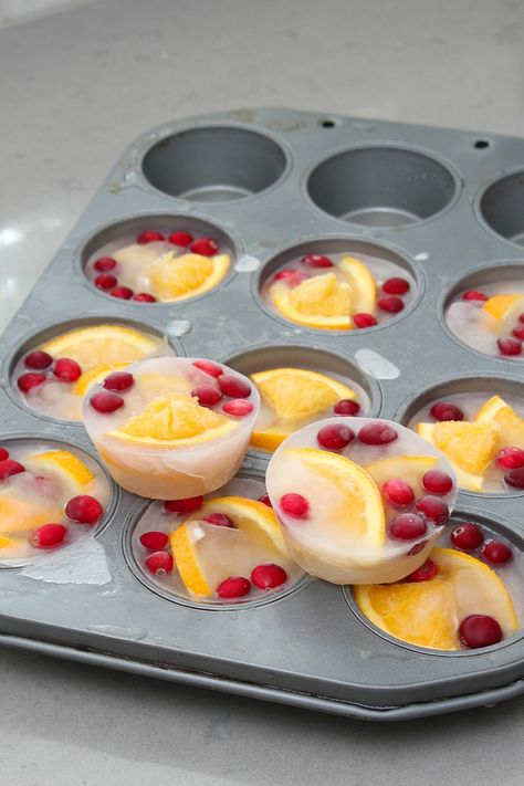 Dress up your holiday punch bowl with these pretty fruit filled ice cube cups. #Christmasrecipes #christmasparty #christmasdrinks #icecubes #infusedfruit Ice For Punch Bowl, New Years Ice Cubes, Orange Slice Ice Cube, New Year’s Eve Ice Cubes, Ice Cube Drink Ideas, Fruit Infused Ice Cubes, Diy Punch Bowl Ideas, Ice Cube Fruit, Holiday Mimosa Ice Cubes