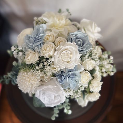 "These beautiful artificial wedding bouquets are made from faux flowers of dusty blue, white and off white, sage greenery and silk eucalyptus. They will make the perfect addition to your big day! This bridal bouquet consists of white roses, peonies and dahlias with green silk eucalyptus and sage greenery and fillers. The stems are wrapped in twine. The bridal bouquet pictured is 12\" (30 cm). Bouquet Size Available: Bridal Bouquet- 12\" (30 cm) Bridesmaids Bouquet - 7\" (18 cm) Toss bouquet 6\" Light Blue Rose Bouquet, Blue And White Wedding Bouquets, Bride Bouquets Blue, Dusty Blue Bridal Bouquet, Bouquet White And Green, Faux Bridal Bouquet, Dusty Blue Bouquet, White And Green Bouquet, Blue Bouquets