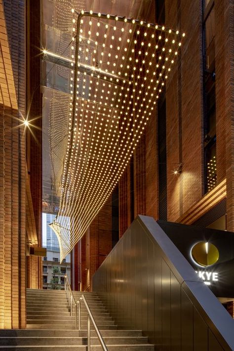 "Reflect" Light Sculpture at Arc by Crown | Tensile Design & Construct Atrium Lighting Design, Atrium Lighting, Catenary Lighting, High Ceiling Lighting, Glass Facade, Corridor Lighting, Colored Led Lights, Facade Lighting, Entryway Lighting