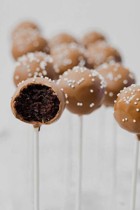 starbucks copycat chocolate coated chocolate cake pops with one bitten in half to show chocolate cake ball middle Cake Pops Recipe Chocolate, Chocolate Cake Pop Recipe, Dairy Free Cream Cheese Icing, Cake Pops From Scratch, Cake Pops Starbucks, Chocolate Cake And Frosting, Easy Cake Pops, Chocolate Cake Pops Recipe, Chocolate Cake Pop