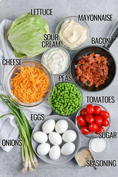 A 7 layer salad is an easy side dish that can be made in advance, making it the perfect dish to bring to a potluck or picnic. What is not to love about the cream dressing made with just a few simple ingredients – mayonnaise, sour cream, a little sugar, and some salt? The salad itself is made with some iceberg lettuce, tomatoes, peas, eggs, and onions. The final touch is the shredded cheese topping and the crispy bacon. So easy, and so good! #7layersalad #overnightsalad #sevenlayersalad #spendwi Layered Salad With Peas, Eggs And Onions, Overnight Salad, 7 Layer Salad, Lettuce Salad Recipes, Layer Salad, Pea Salad Recipes, Seven Layer Salad, Layered Salad Recipes