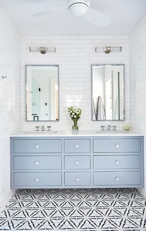 A light blue dual washstand accented with square glass knobs is fitted with a white quartz countertop holding his and hers sinks beneath polished nickel cross handle faucets. His And Hers Sinks, Interior Design Minimalist, Double Vanity Bathroom, Subway Tiles, Bathroom Trends, Upstairs Bathrooms, House Bathroom, Bathroom Remodel Master, Kids' Bathroom