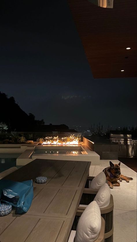 Los Angeles cozy evening outside with a german shepherd , infinity pool view over DTLA cream pillows earth tones interior design outdoor design fireplace California n Las Angeles Apartments, Los Angeles Aesthetic House, Los Angeles Luxury Apartment, California Mansion Aesthetic, Los Angeles House Interior, Los Angeles Mansion Aesthetic, Los Angeles Houses Aesthetic, Los Angeles House View, La Mansion Interior