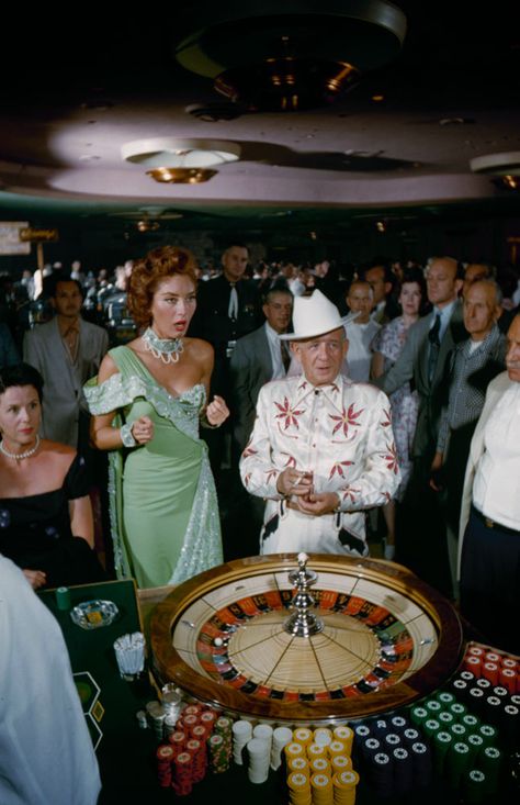 1955 fashion style found photo las vegas gambling roulette table woman lady mint green blue evening gown man in white suit cowboy hat 50s vintage Las Vegas 1960s, 60s Casino Fashion, Old School Vegas Fashion, Vintage Las Vegas Showgirl, Las Vegas 1980s, 50s Night Club, Casino Night Aesthetic, 60s Casino, Old Vegas Aesthetic