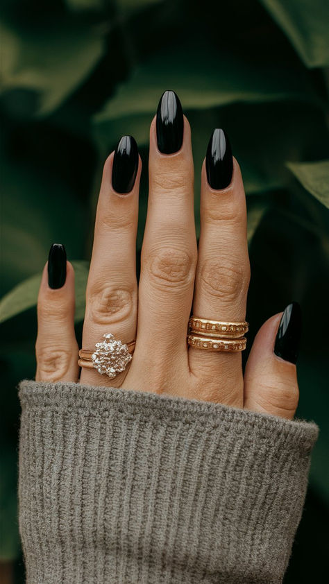 Elevate your style with these classy almond-shaped black nails, an embodiment of sophistication and modern flair. The sleek design offers a polished finish that complements any outfit, making them perfect for a chic evening out or a refined daytime look. Embrace the allure of simplicity and let your nails make a statement of elegant confidence. 💅🌟 Bridesmaid Black Nails, Plain Black Almond Nails, Matte Black Nails Almond, Classy Black Nail Designs, Dark Moody Nails, Black And Gold Almond Nails, Black And Chrome Nails, Almond Black Nails, Black Nails Almond