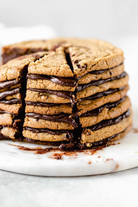 This chocolate chip cookie cake is the ULTIMATE cookie lovers dessert. This cookie layer cake has 7 layers of chewy chocolate chip cookies loaded with chocolate. The cookie layers are stacked with a delicious and rich chocolate ganache. If you love chocolate chip cookies, you will fall in love with this cake! #chocolatechipcookiecake #cookiecake #cookielayercake #chocolatechipcookies #ganache #bakedambrosia Cookie Layer Cake, Sesame Cookies, Vegan Greek, Giant Chocolate Chip Cookie, Make Chocolate Chip Cookies, Ultimate Cookies, Chocolate Chip Cookie Cake, Giant Chocolate, Chewy Chocolate Chip