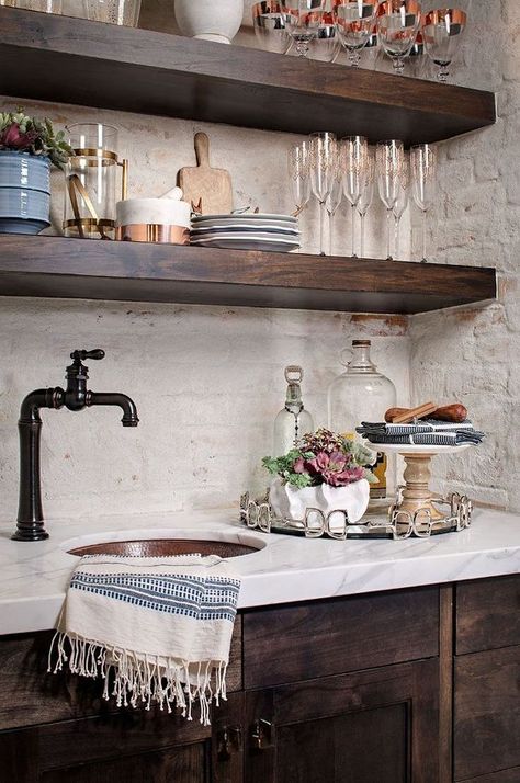 The rustic wood of the cabinets here really contrast with the marble and that is a really stylish look. The dark colors and the old-style faucet really help enhance that idea too. Painted Brick Backsplash, Backsplash With Dark Cabinets, Farmhouse Kitchen Backsplash, Bar Mini, Farmhouse Interior Design, Herringbone Backsplash, Brick Backsplash, Farmhouse Kitchen Cabinets, Farmhouse Kitchen Design