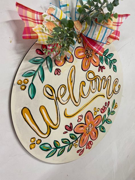 This floral wood Welcome door hanger provides a Welcoming entrance  and greeting to your home when added to your front door decor, porch decor, patio decor or interior space. A beautiful gift for that special person or relative or occasion. Sunflower Wooden Door Hanger, Circle Wooden Door Hangers, Circle Wood Door Sign, Hand Painted Door Signs, Diy Painted Door Hangers, Round Painted Door Hanger, Fall Door Signs Diy, Circle Welcome Sign Front Door, Hand Painted Door Hangers