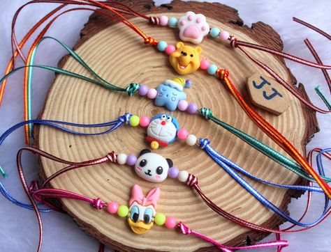 KIDS RAKHI RATE: Rs 110 PER PCS. ⁵/5 BULK RATE FOR 12 PCS: Rs 80. ⁰⁴ SHIPPING CHARGES EXTRA Clay Rakhi Design, Rakhi Designs Handmade Unique Diy, Rakhi Pictures, Diy Rakhi Handmade Ideas, Mdf Jewellery, Colourful Video, Clay Rakhi, Rakhi For Kids, Rakhi 2024