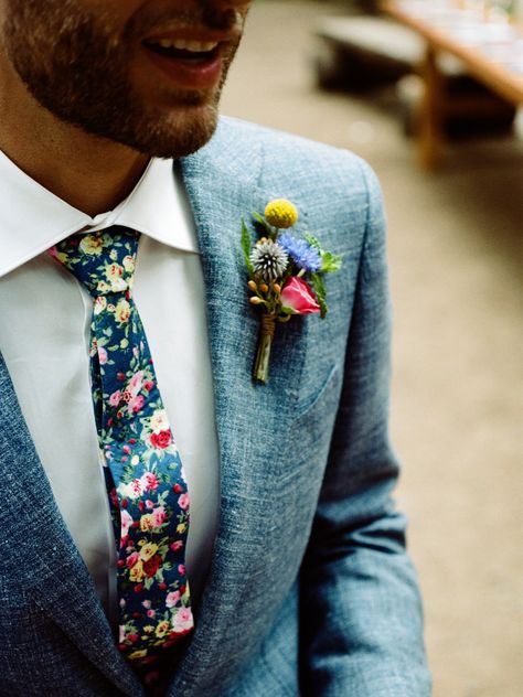 Colorful boutonniere witih matching floral tie. spray rose, thistle, delphinium, craspedia and fern. Photo by Benj Haish. Lake Cushman, WA Floral Tie Wedding Groomsmen, Colourful Groom Suit, Spring Tuxedo Wedding, Wildflower Tie, Floral Tie Groomsmen, Spring Groom, Colorful Boutonniere, Floral Tie Groom, Fern Photo