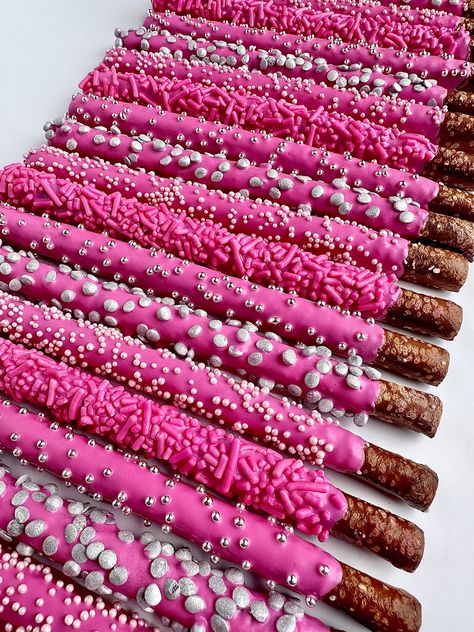 This listing is for 12 chocolate covered pretzels. Each fresh pretzel rod is dipped in creamy hot pink chocolate and decorated with 4 different sprinkles. A perfect addition to a dessert table, a birthday party or shower. So beautiful that all the guests will want one.  Each favor will arrive to you individually wrapped in a clear cellophane sleeve and tied with color coordinating ribbons.  Delightful Chocolates cannot be held responsible for melted chocolate once the package has left our facility. We take great pride in insulating our boxes and packaging with ice sheets if needed PLEASE PURCHASE ICE SHEETS IF YOU LIVE IN A WARM CLIMATE. WE WILL NOT SHIP IF YOU ARE IN TEMPERATURES OF 65 DEGREES OR ABOVE  These confections were crafted in a workplace that also processes peanuts and other tr Stuff To Ask For Your 13 Birthday, Pink Sweet 16 Food, Pink Birthday Party Drinks, Hot Pink Chocolate Covered Pretzels, 18th Bday Party Ideas Pink, Y2k Party Desserts, Aesthetic Pink Dessert, Barbie Themed Birthday Party Food Ideas, Hot Pink And Black Dessert Table