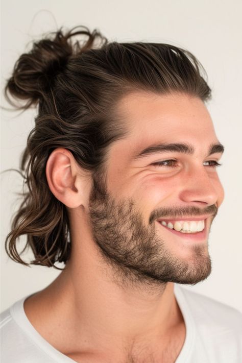 For this easy style, the top section of hair is pulled back into a bun, leaving the rest to flow freely. It's a trendy and functional style that offers the best of both worlds – it keeps the hair off the face while showcasing the length and volume. Click here to see more long hairstyles for men. Long Dark Hair Men, Viking Hair Men Short, Long Hairstyles For Men, Long Beard Styles, Long Hair Trends, Beard Styles Short, Guy Haircuts Long, Best Beard Styles, Mens Hairstyles Medium