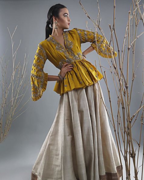 An ochre yellow Peplum blouse design that would totally go with the bridal as well as the bridesmaid's outfit. #shaadisaga #blousedesign #blousestyle #weddinginspo #bridesmaidoutfit #outfitgoals #indianoutfit #indianfashion #lehenga #indianwear #weddinginspiration #outfitgoals Latest Peplum Styles, Style Blouse Designs, Peplum Top Outfits, ड��िजाइनर कपड़े, Long Blouse Designs, Lehenga Blouse Designs, Indian Gowns Dresses, Indian Gowns, Designer Party Wear Dresses