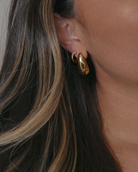 Gold statement tear drop stud earrings paired with a gold double hoop cubic zirconia detail earring