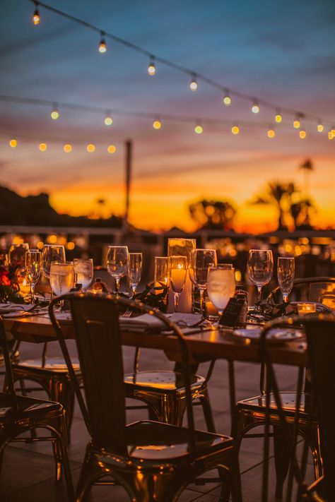 the most magical rooftop reception made even more magical by the arizona sky + desert mountains!! The most brilliant candles and copper and gold chairs and silverware with white plates and wooden tables were perf!! Also love the string lights and small florals as centerpieces with personalized notes from bride + groom to each guest!! Love that idea! | Photo by: Olivia Markle #wedding #elopement #modernwedding #bridals #sunset #receptioninspo Sunset Table Decor, Rooftop Wedding Ideas, Wedding At Sunset, Sunset Wedding Reception, Rooftop Wedding Reception, Rooftop Reception, Gold Chairs, Sunset Captions For Instagram, Sunset Party