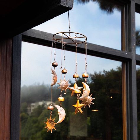 Sun, Moon, and Stars Mobile Bring the sun, moon and stars into your own backyard with this celestial mobile. The circular mobile, which also features bells, chimes gently when it sways in the breeze. The natural-colored pendants go well with just about every style of home and garden, making this piece a great gift for friends and family. Like all Happy Gardens mobiles, this item has been individually handcrafted. Features Of This Mobile *Sound Of Product In Video Is Taken In A Gusting Wind* Dime Whimsy Interior, Wind Chimes Aesthetic, Celestial Mobile, Howls Bedroom, Marceline Fashion, Universal Codes, Circle Mobile, Stars Mobile, Witch Room